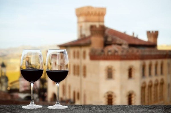 Two glasses of Barolo and the Castle of Barolo in the background. Photo Credit: www.svino.it