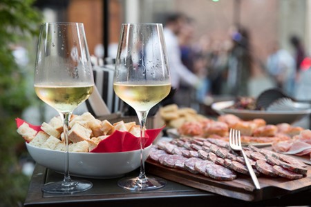 Prosecco di Valdobbiàdene with bread, prosciutto and salami. Photo Credits www.periniprosecco.it