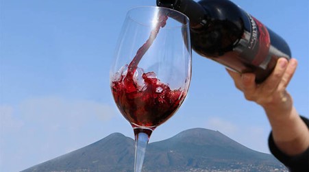 A glass of Lacryma Christi red wine with the view of Mount Vesuvius. Photo Credits: www.fisarmilano.org (magazine)