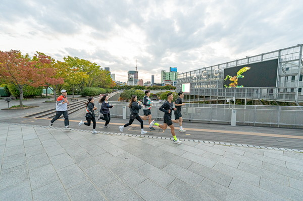 미디어아트 전시 ‘반디산책 : 지구와 화해하는 발걸음’을 배경으로 시민들이 국립아시아문화전당 일대를 달리고 있다