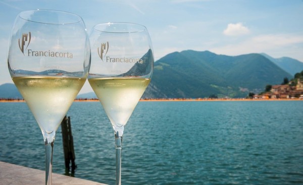Glasses of Franciacorta on the shores of Lake Iseo. Lombardy region – Italy. Photo Credits www.inchiostrovirtuale.it