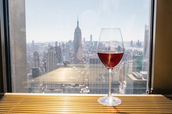 A glass of red wine with Midtown Manhattan in the background. New York City. Photo Credits: www.alcoholprofessor.com via Brindamour Photography.