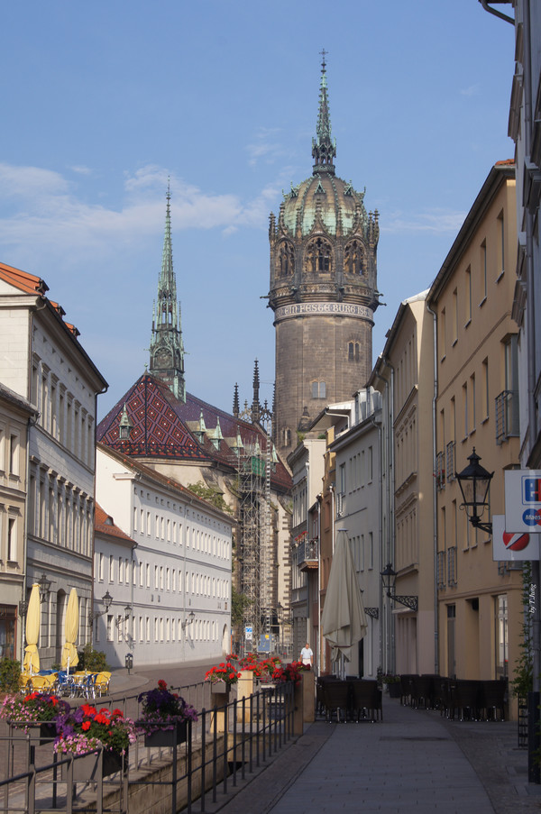 비텐베르크 성 부속 교회의 원통형 첨탑이 보이는 거리