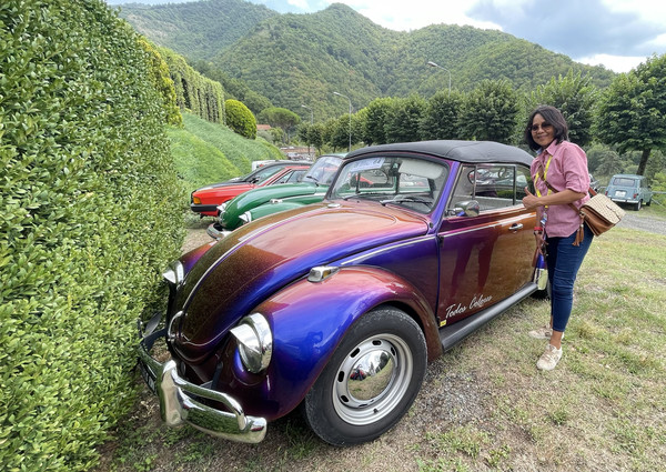 Maureen next to a Volkswagen Beetle at the historical car rally in Mugello, Tuscany