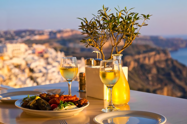 A glass of white wine from Assyrtiko grapes with the astonishing view of Santorini. Credits: www.identitagolose.it